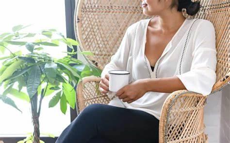 Picture of a woman sitting contentedly with a cup of coffee